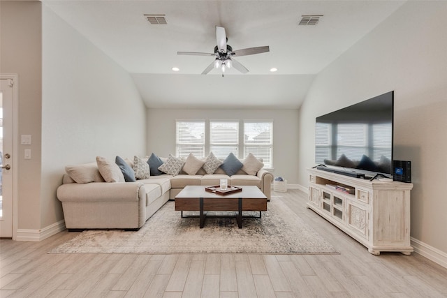 living room featuring lofted ceiling, a ceiling fan, visible vents, and light wood-style floors