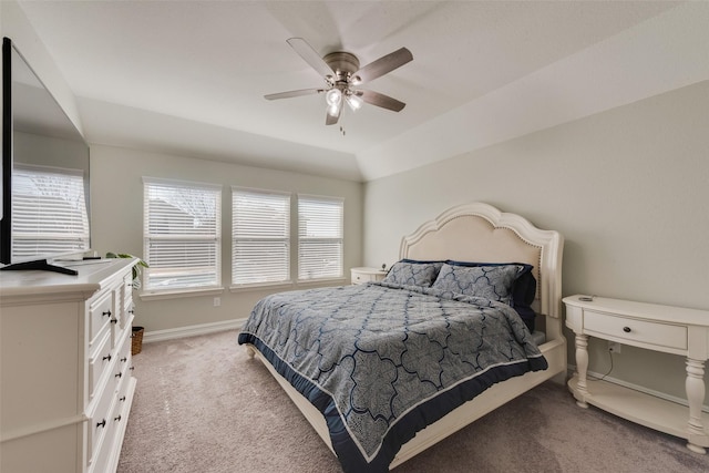 bedroom with a ceiling fan, light colored carpet, vaulted ceiling, and baseboards