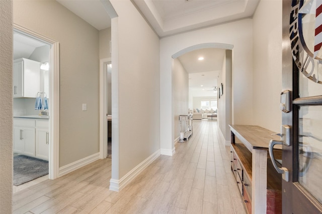 hall with ornamental molding and light hardwood / wood-style floors