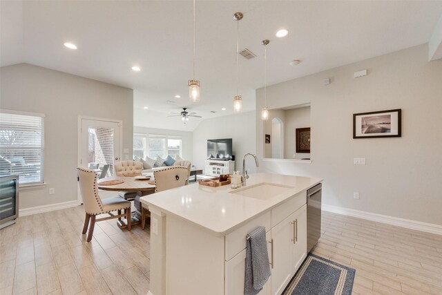 kitchen with lofted ceiling, light countertops, a sink, and hanging light fixtures