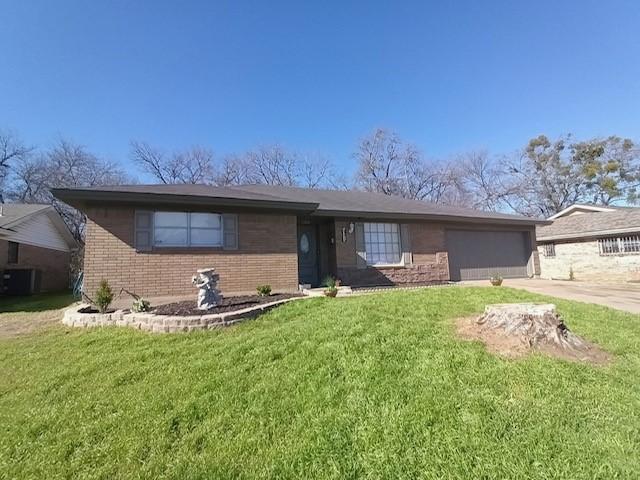 ranch-style home featuring cooling unit, a garage, and a front lawn