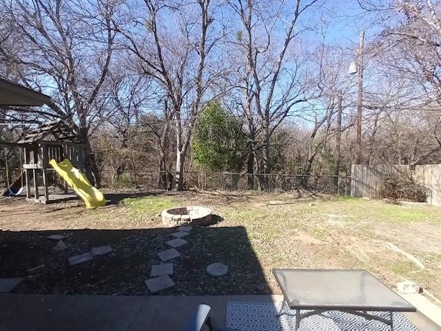 view of yard featuring a playground and a fire pit