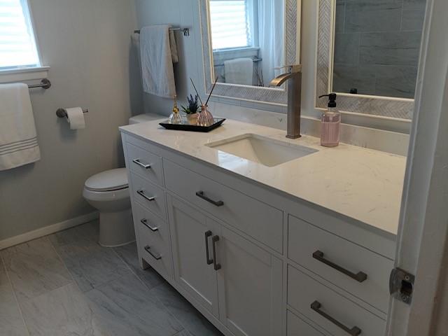 bathroom with vanity, a wealth of natural light, and toilet