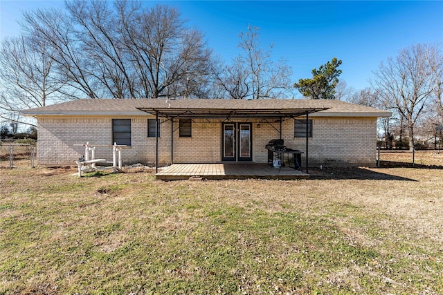 rear view of property with a wooden deck and a lawn