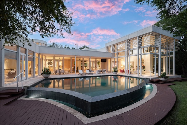 pool at dusk with a patio area