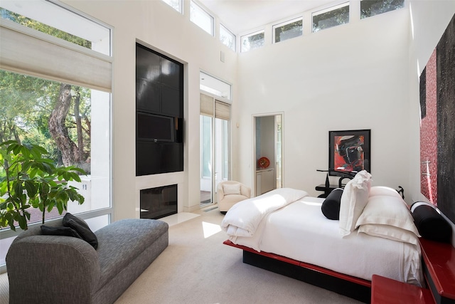 bedroom with a towering ceiling and light colored carpet