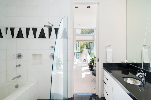 bathroom featuring tiled shower / bath combo and vanity