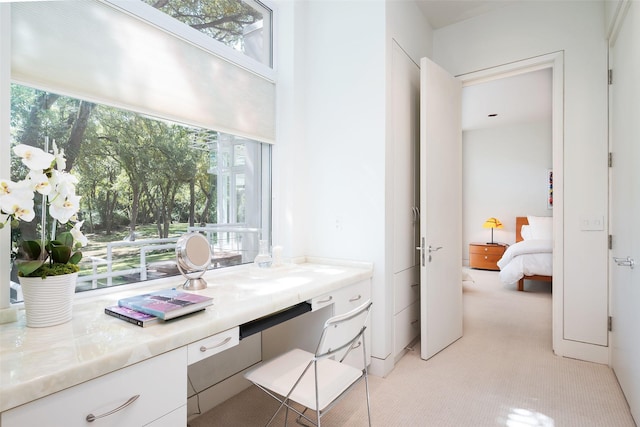 home office featuring light carpet and built in desk