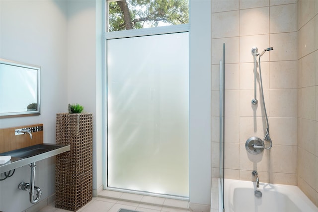 bathroom featuring tiled shower / bath combo and tile patterned flooring