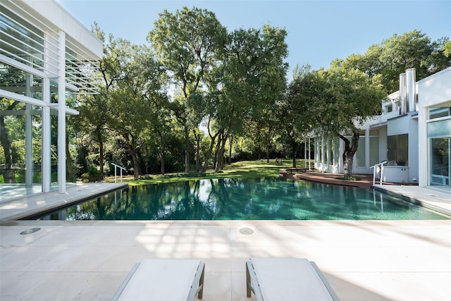 view of pool featuring a water view and a patio