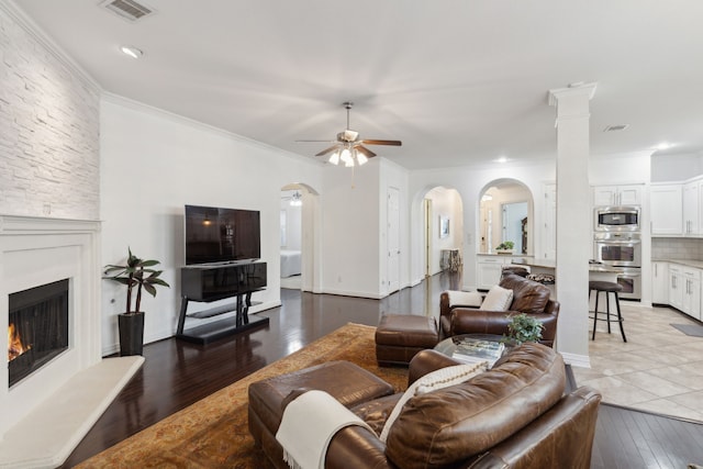 living room featuring ornamental molding, ceiling fan, and light wood-type flooring