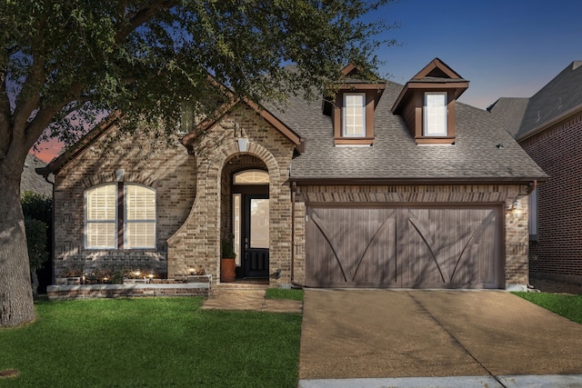 view of front facade with a yard and a garage