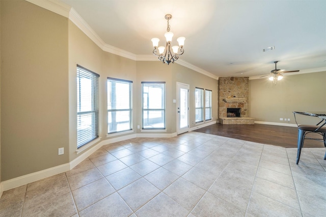 unfurnished living room with ornamental molding, a stone fireplace, ceiling fan with notable chandelier, and light tile patterned floors