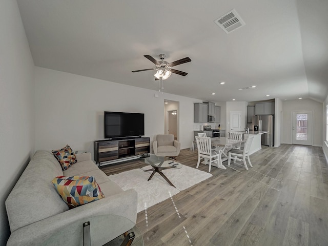 living room featuring ceiling fan and light hardwood / wood-style flooring