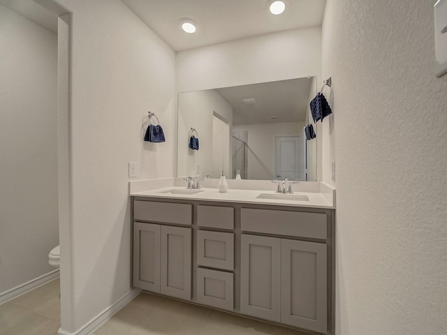 bathroom with tile patterned flooring, vanity, and toilet