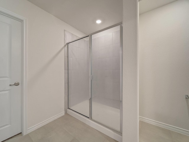 bathroom with tile patterned flooring and a shower with door