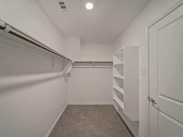 spacious closet featuring dark colored carpet