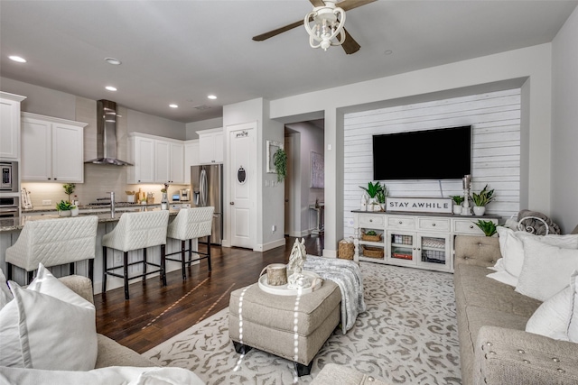 living room featuring ceiling fan and dark hardwood / wood-style floors