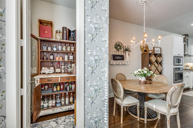 dining area featuring dark wood-type flooring and a notable chandelier