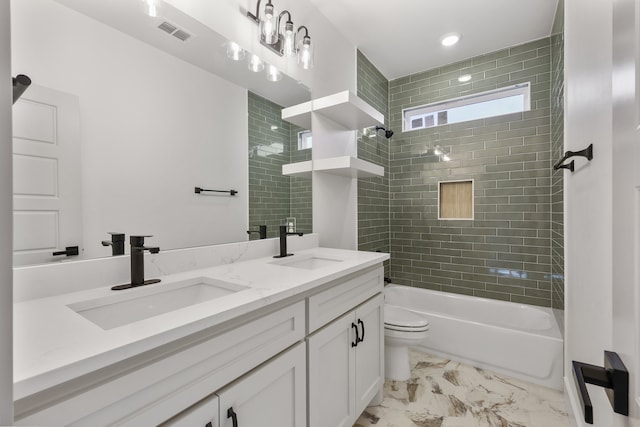 full bathroom featuring tiled shower / bath combo, vanity, and toilet