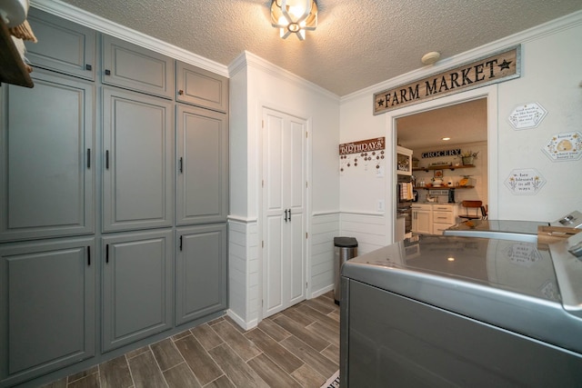 washroom featuring separate washer and dryer, ornamental molding, cabinets, and a textured ceiling