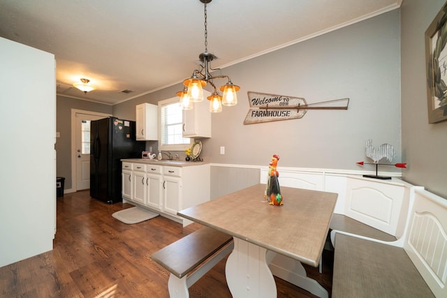 dining space featuring ornamental molding, dark wood-type flooring, and sink