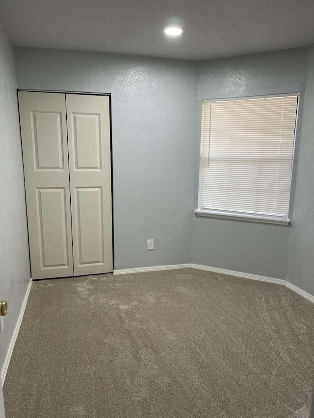 unfurnished bedroom with carpet floors and a closet