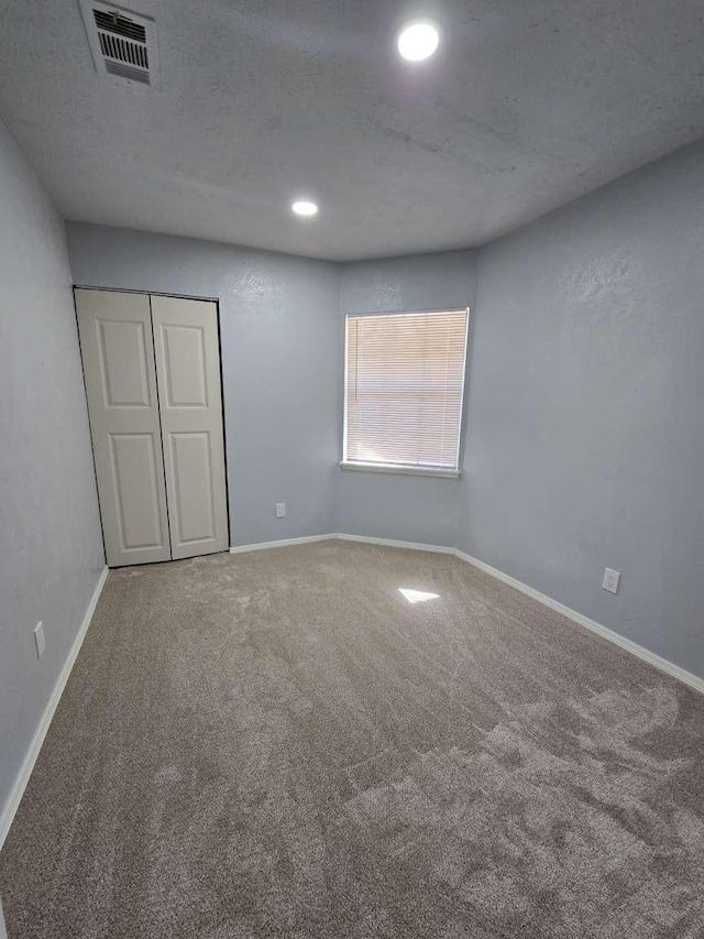 interior space featuring carpet and a textured ceiling