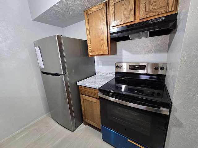 kitchen featuring stainless steel appliances and a textured ceiling