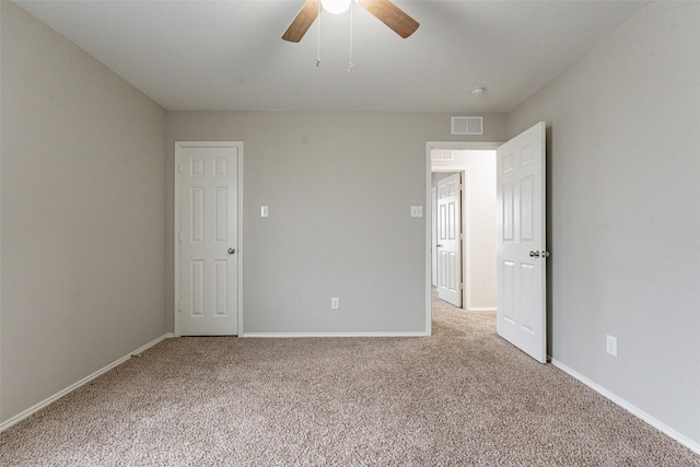 unfurnished room with ceiling fan and carpet