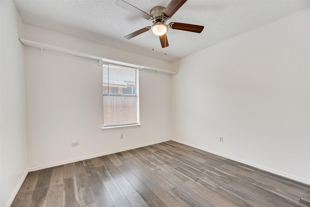 empty room with ceiling fan, hardwood / wood-style floors, and a textured ceiling