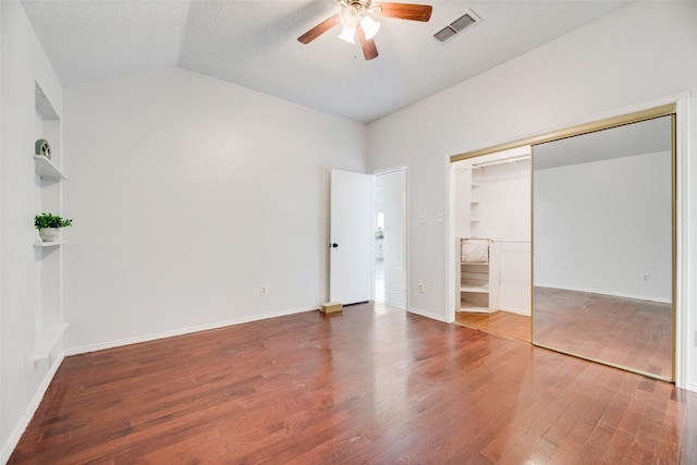 unfurnished bedroom with vaulted ceiling, hardwood / wood-style floors, ceiling fan, and a closet