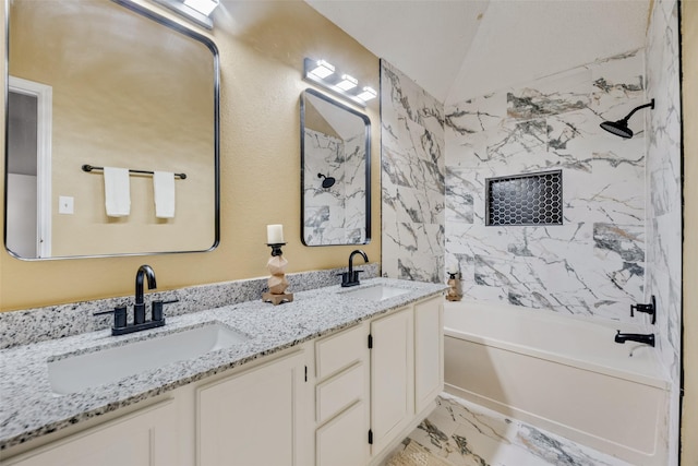 bathroom featuring vanity, lofted ceiling, and tiled shower / bath