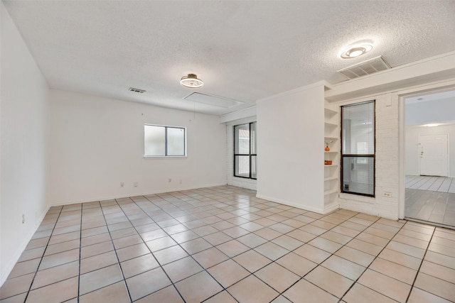 spare room featuring light tile patterned floors and a textured ceiling