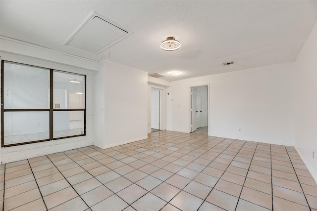 tiled spare room with a textured ceiling