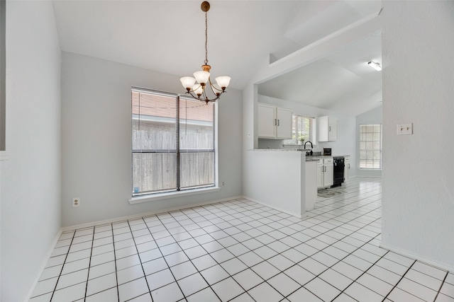 tiled empty room featuring lofted ceiling, sink, and a chandelier