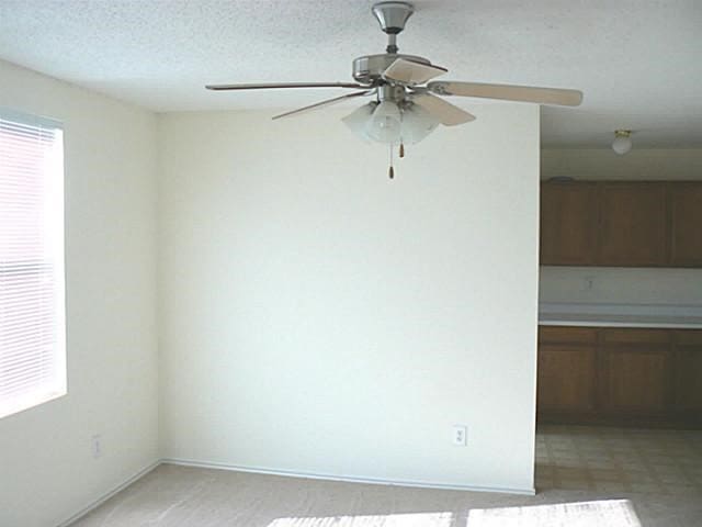 unfurnished room featuring ceiling fan and a textured ceiling