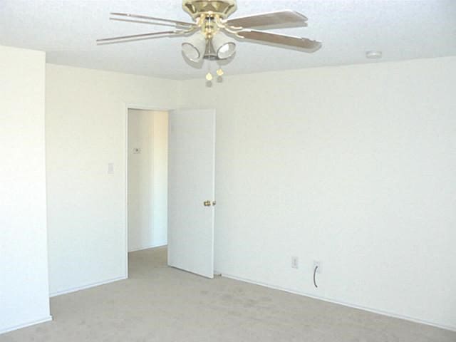 carpeted empty room with ceiling fan