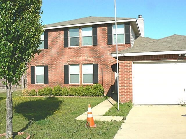 colonial-style house featuring a garage and a front lawn