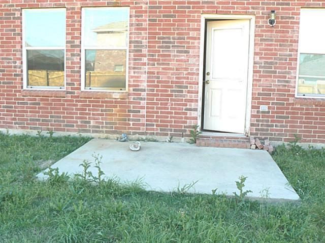 property entrance featuring a yard and a patio area