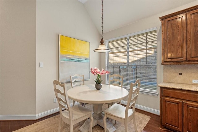 dining room featuring lofted ceiling and dark wood-type flooring