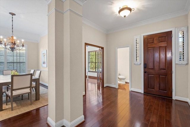 foyer entrance featuring an inviting chandelier, crown molding, and dark wood-type flooring