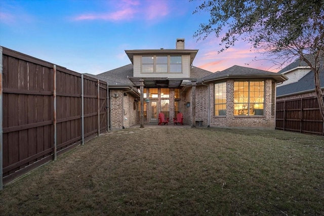 back house at dusk with a yard