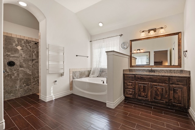 bathroom with lofted ceiling, plus walk in shower, radiator, and vanity