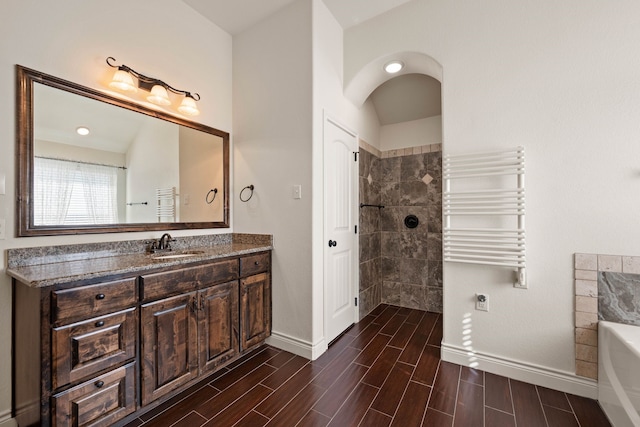 bathroom featuring vanity, a bathing tub, and radiator