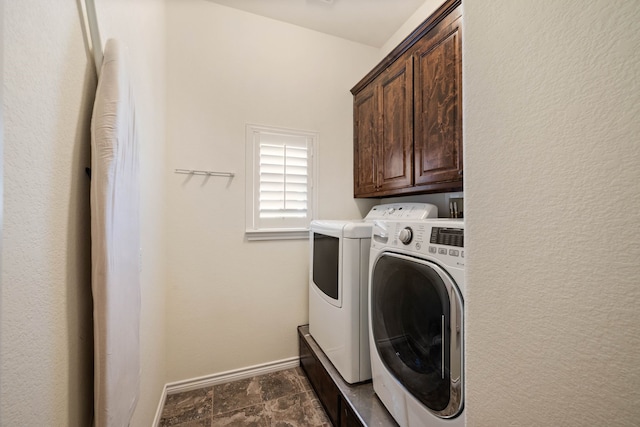 clothes washing area featuring cabinets and separate washer and dryer