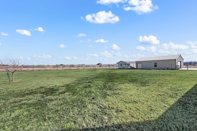 view of yard featuring an outdoor structure and a rural view