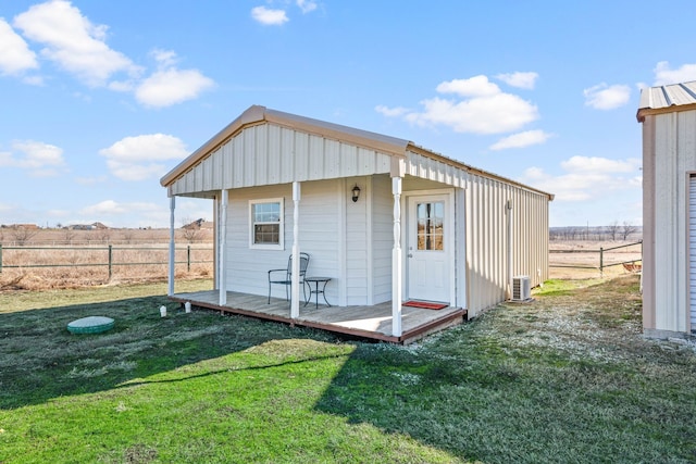 view of outbuilding with a rural view, cooling unit, and a lawn