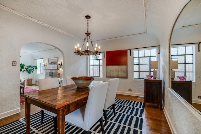 dining space featuring crown molding, a wealth of natural light, a textured ceiling, and dark hardwood / wood-style flooring