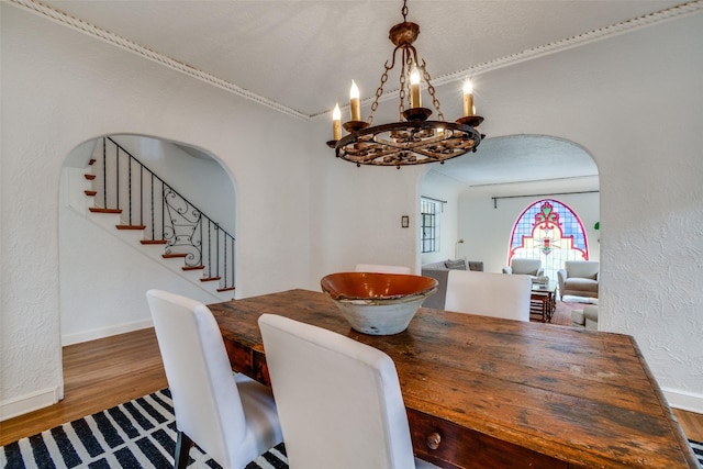 dining space featuring wood-type flooring and ornamental molding